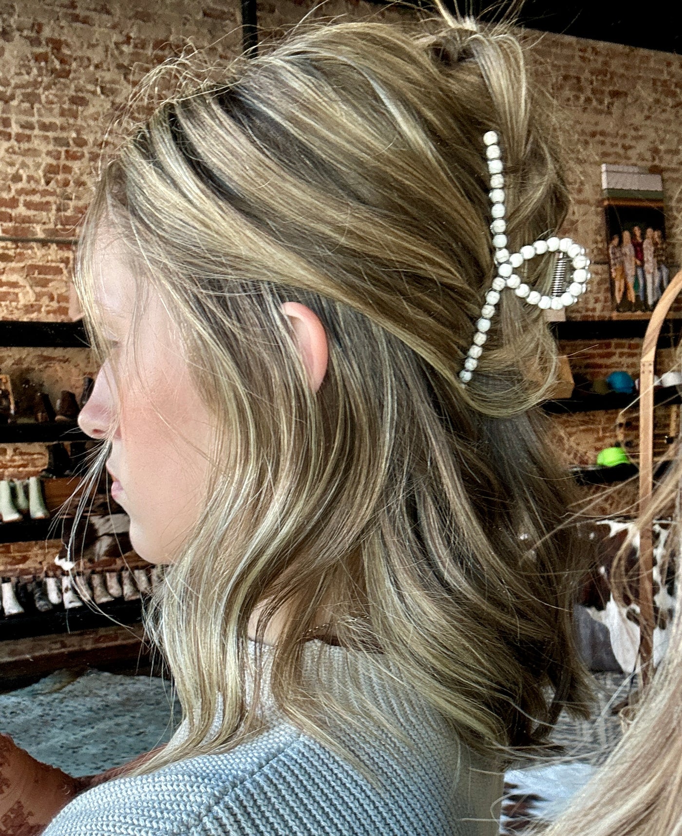 A woman modeling our Wendy White Buffalo Bead Hair Claw Clip in her hair.