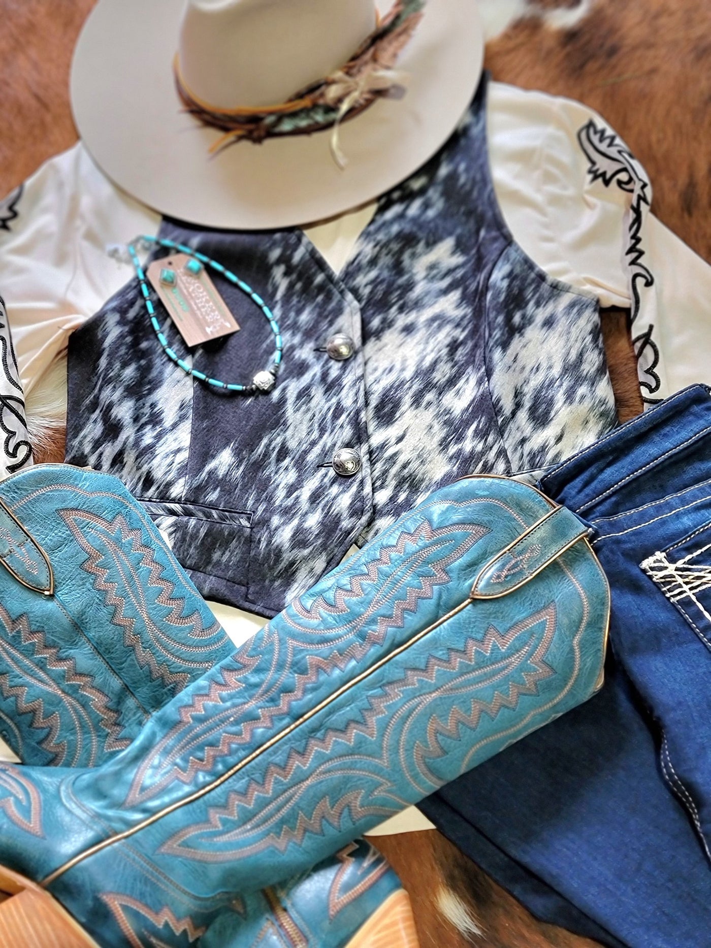 A woman's NFR style outfit featuring Ariat Casanova boots and the Open Gate S&P Cowhide Vest available at Broker Leather.