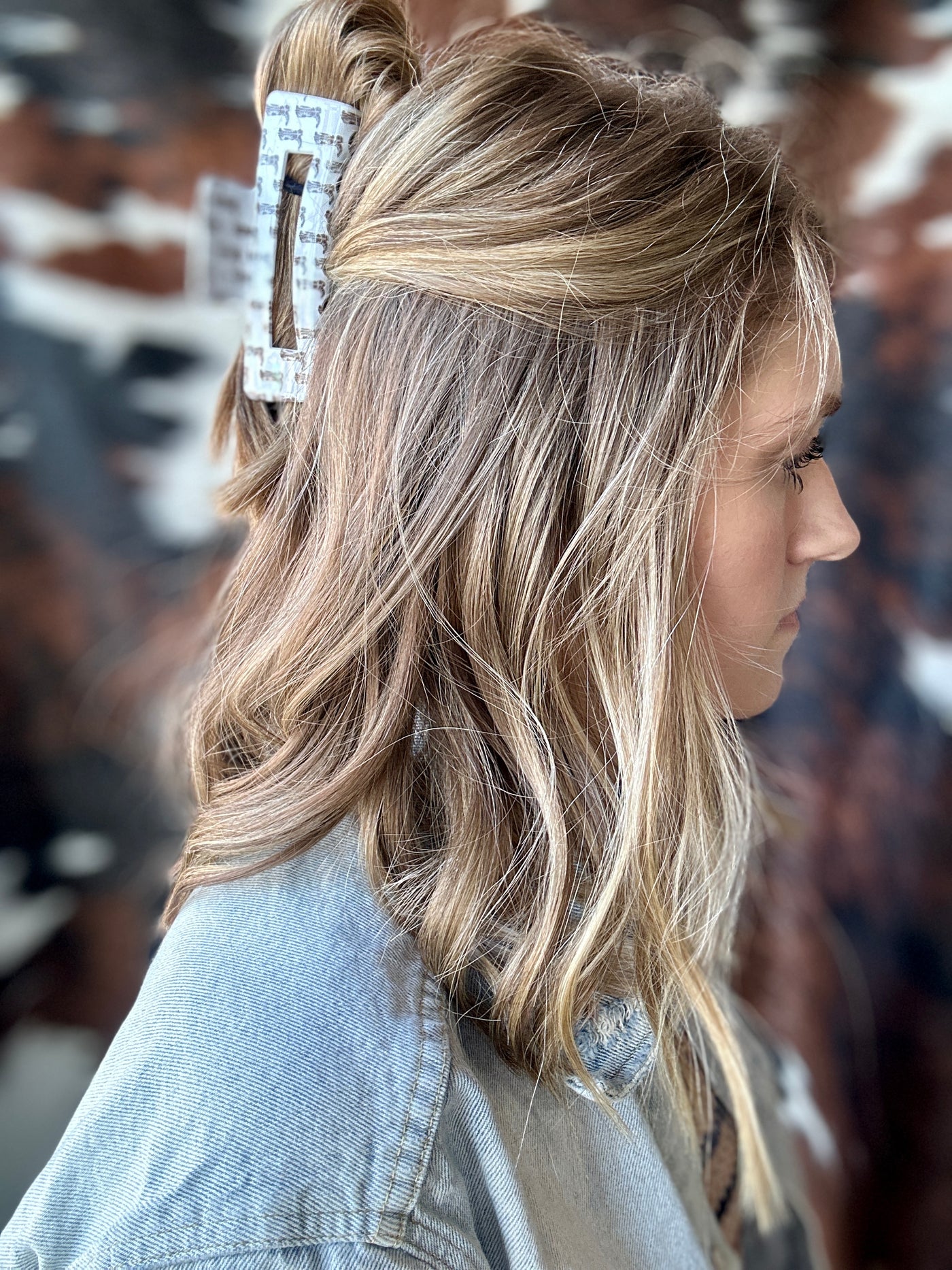 A woman modeling our Alisha Cowboy Boot Print Claw Clip in her hair.