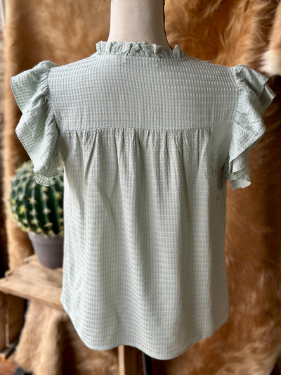 Lightweight sage green blouse with ruffle sleeves and v-neckline.