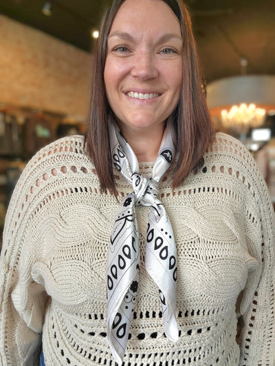 Photo of employee, woman modeling our Amara Cream Paisley Wild Rag tied in a 4-square knot.