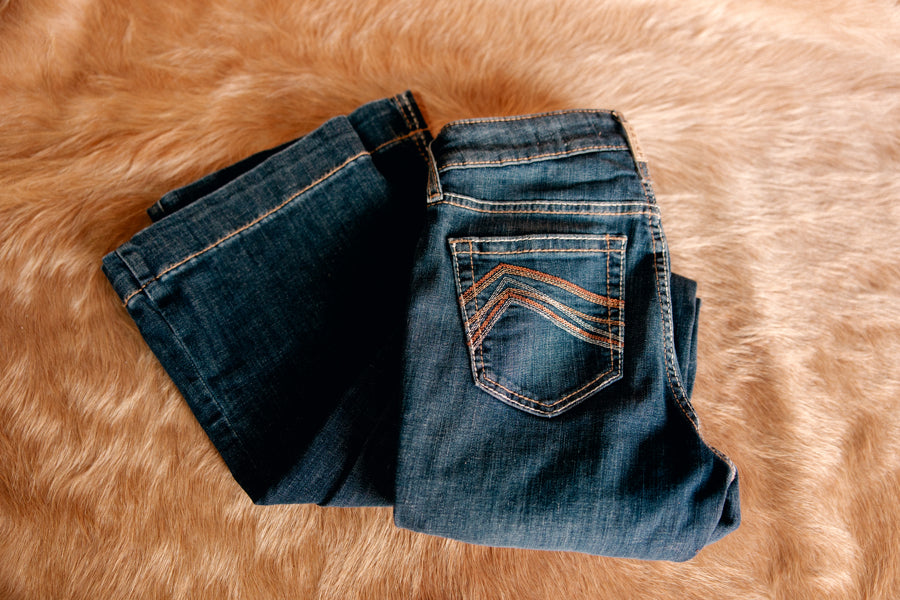 Flat lay on neutral background of the Ariat High Rise Kimber Slim Trouser.