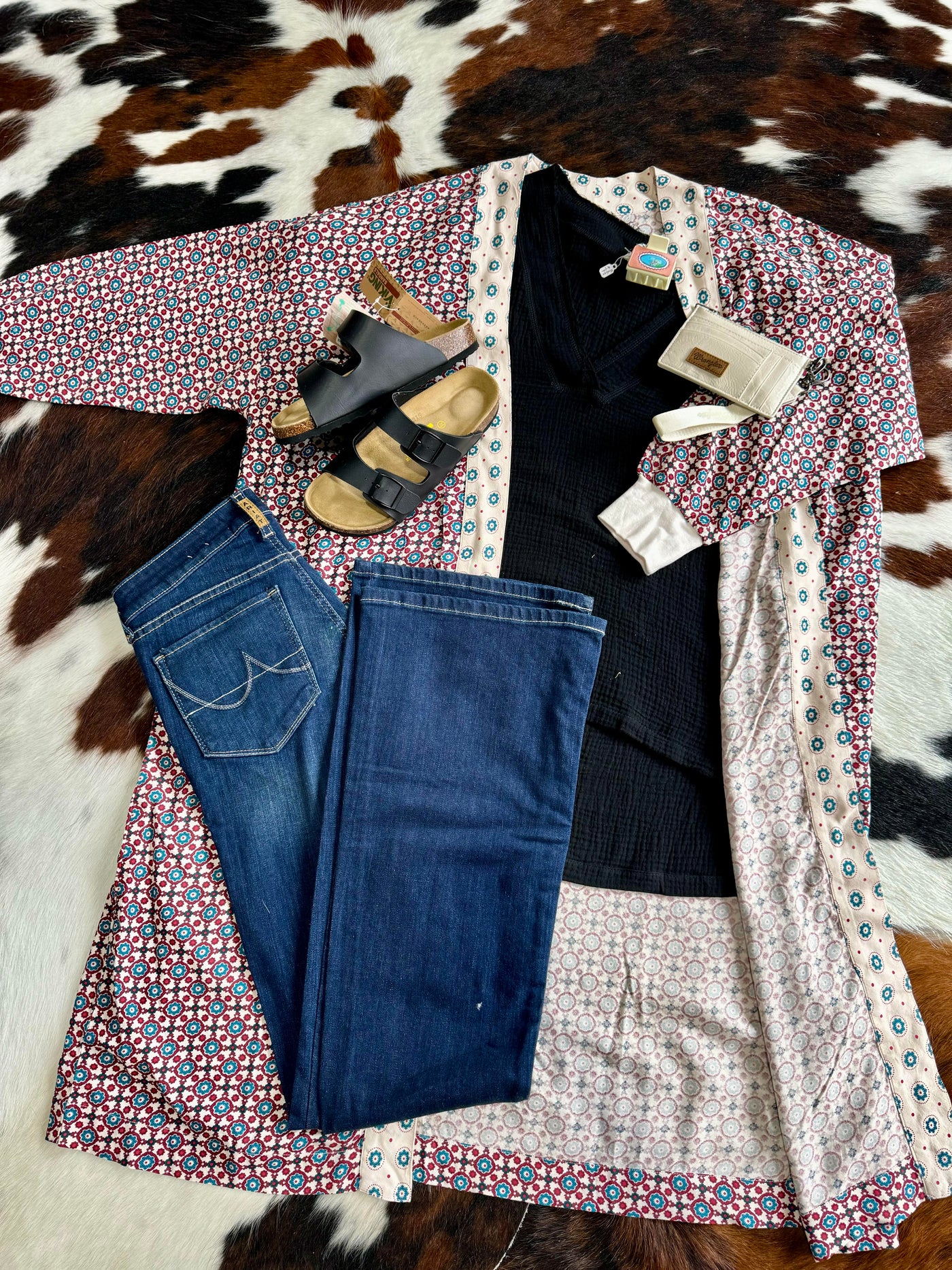 A flatlay picture showcasing an outfit around our red, white, and blue Ariat Mesquite Kimono Duster.