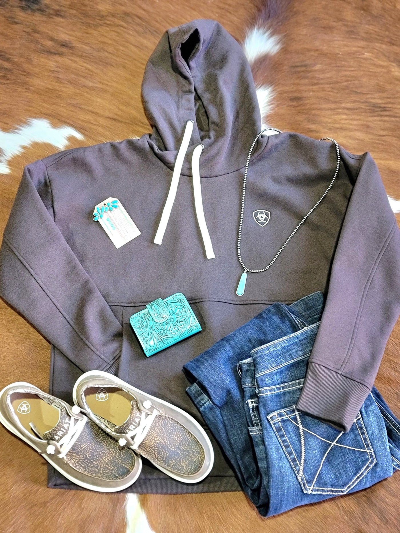 Flatlay photo of our Ariat Rabere Hoodie [Mole/Brown] with Ariat shoes & jeans.