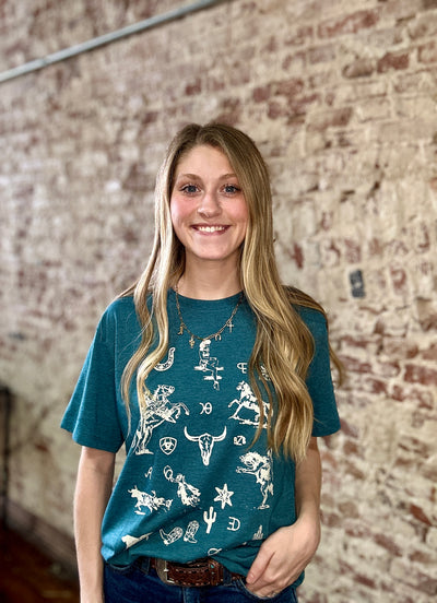 Broker Leather model wearing the deep turquoise Ariat Sketch Pad Graphic Tee styled for casual wear, made with USA-grown cotton.