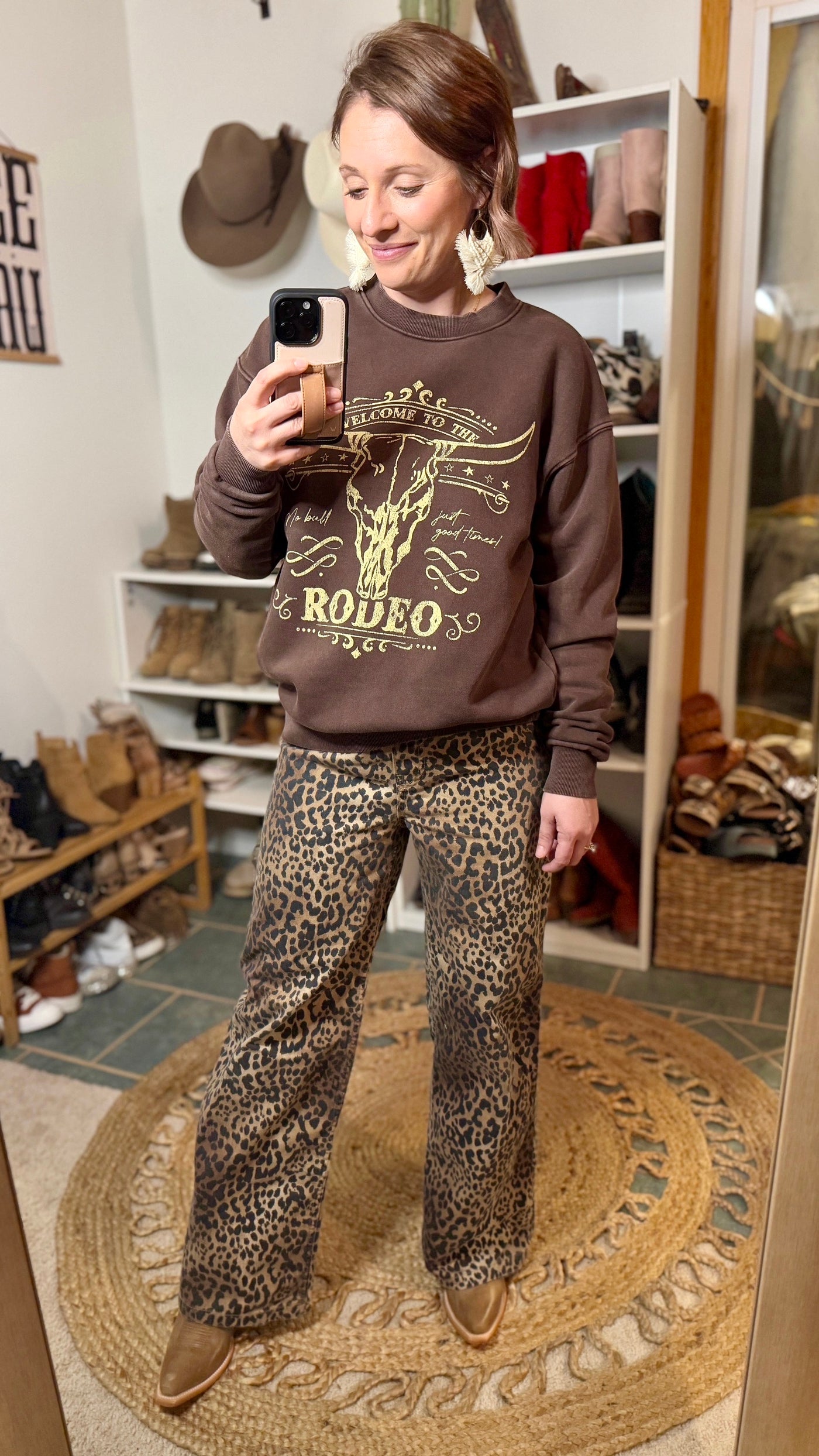 Cowgirl wearing the Ariat Starlight Snip Toe Boot with cheetah printed denim and a Western graphic tee, stepping into the spotlight with a bold and edgy look.