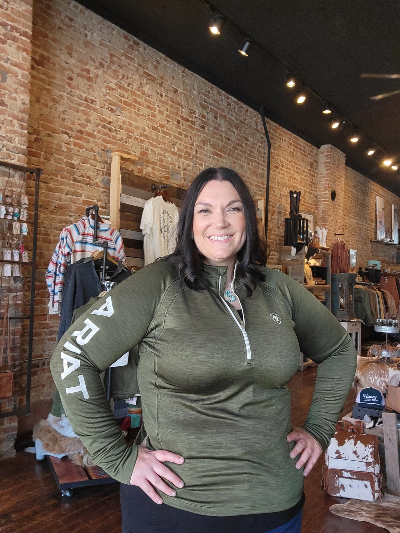 Model from Broker Leather wearing Ariat Tek Team 1/2 Zip Sweatshirt [Winter Moss], featuring a flattering and functional fit.