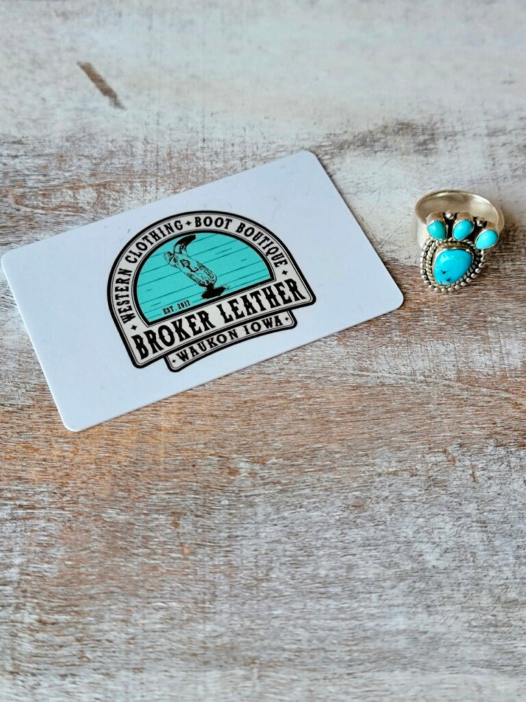 Timeless Western Ring with a Turquoise Centerpiece and Delicate Accents photographed next to a plastic gift card for size relevance.