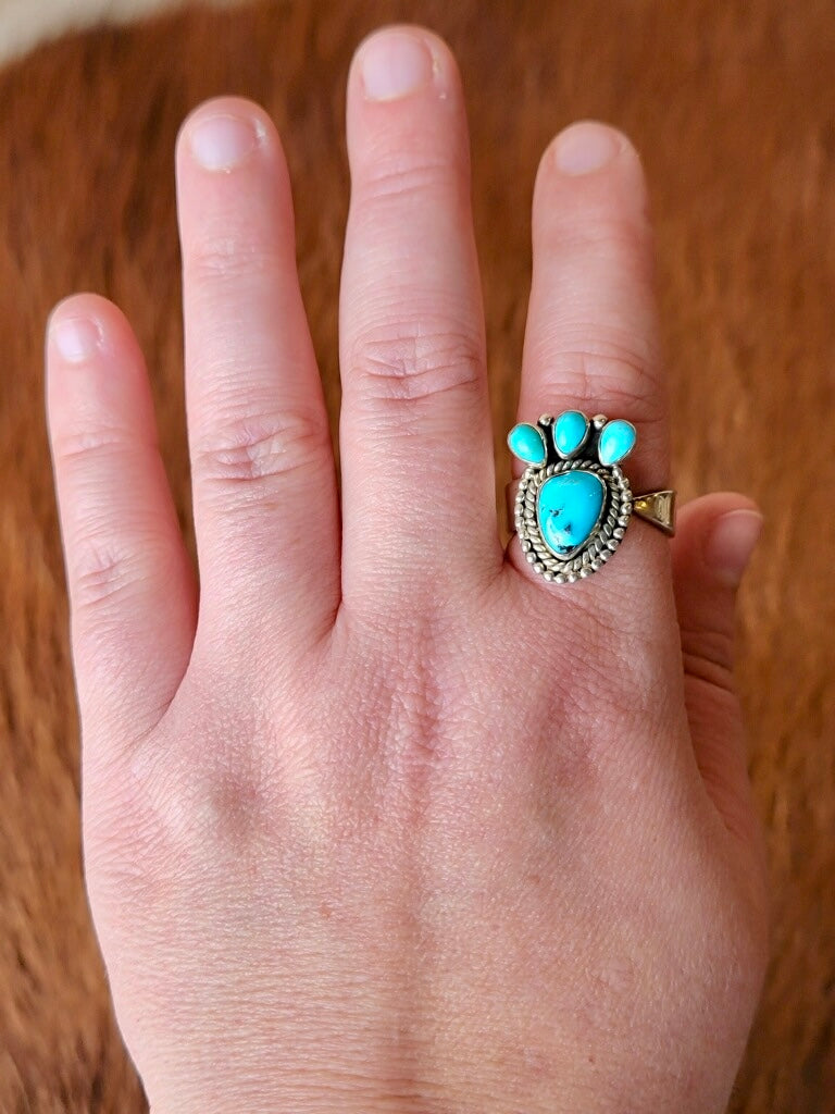 Close-up of Atrina Adjustable Turquoise Ring with Traditional Stamping shown on a hand.