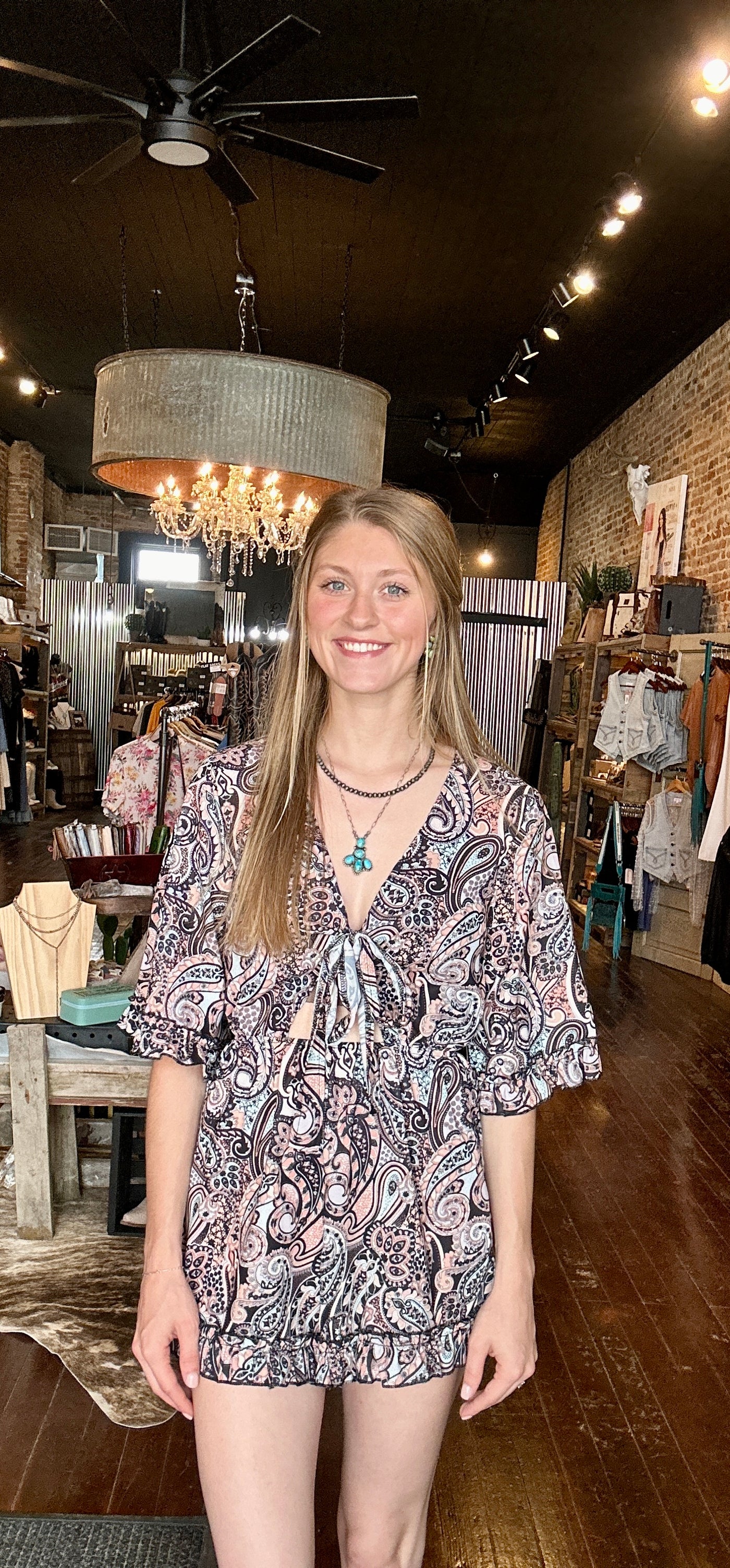 Full view of the Aurora Paisley Romper modeled by a Broker Leather employee, perfect for casual outings or summer days.