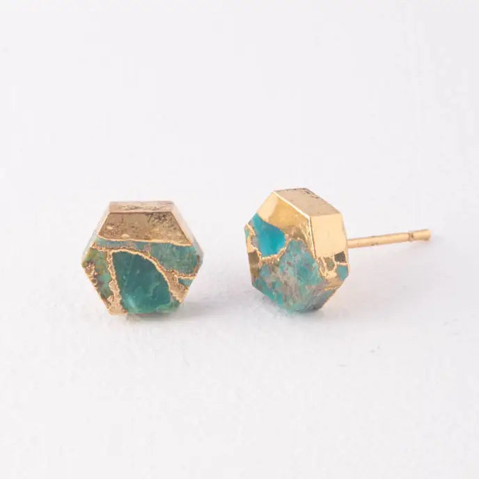 Close-up of petite hexagon turquoise stud earrings dipped in gold, showing raw natural texture