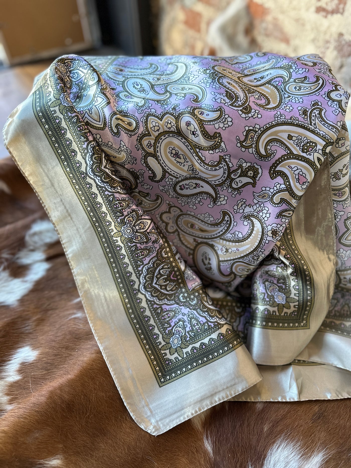 Flatlay photo showing a closeup of the the Beatrice Lavender & Tan Paisley Wild Rag.