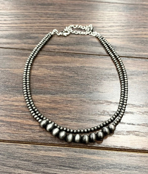 Detailed image of the Becca Necklace's layered design, featuring a special clasp to keep strands separate and tangle-free.