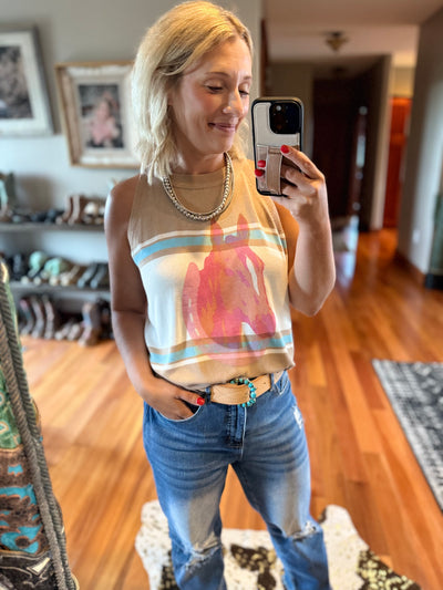 Woman taking a mirror selfie showcasing a western leather belt and turquoise cluster belt buckle.