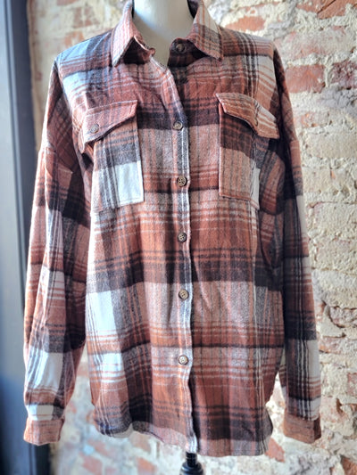 A trendy and practical rusty brown and orange plaid shacket for fall and winter layering.