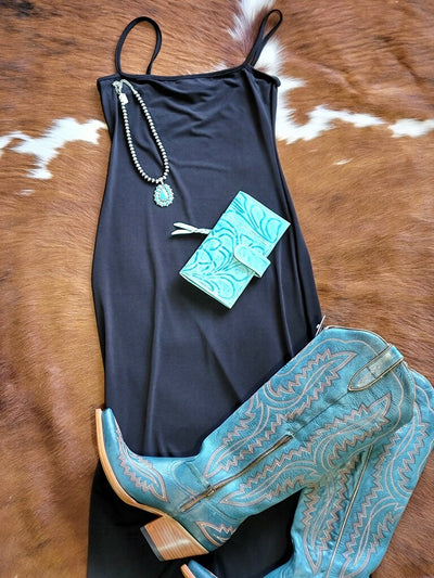 Elegant black maxi dress with spaghetti straps, ideal for highlighting a sun-kissed glow, cowgirl boots, and turquoise jewelry.