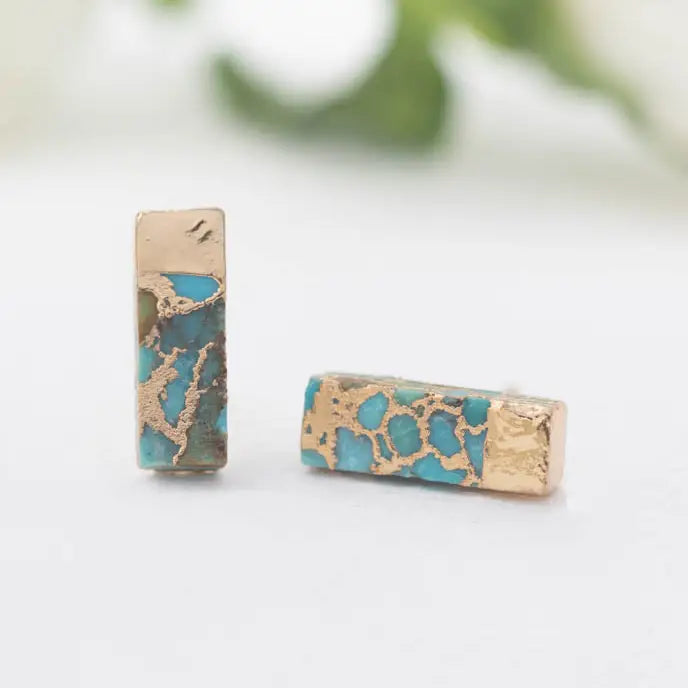 Close-up of tiny turquoise bar earrings featuring natural stone and 14k gold-plated finish