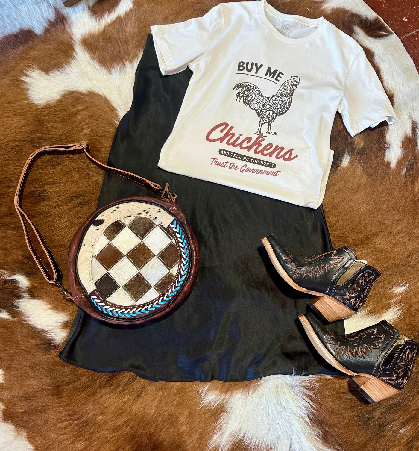 Flatlay photo showing an outfit featuring our Brittany Chickens & Government Graphic Tee paired with Ariat Dixon Boots.