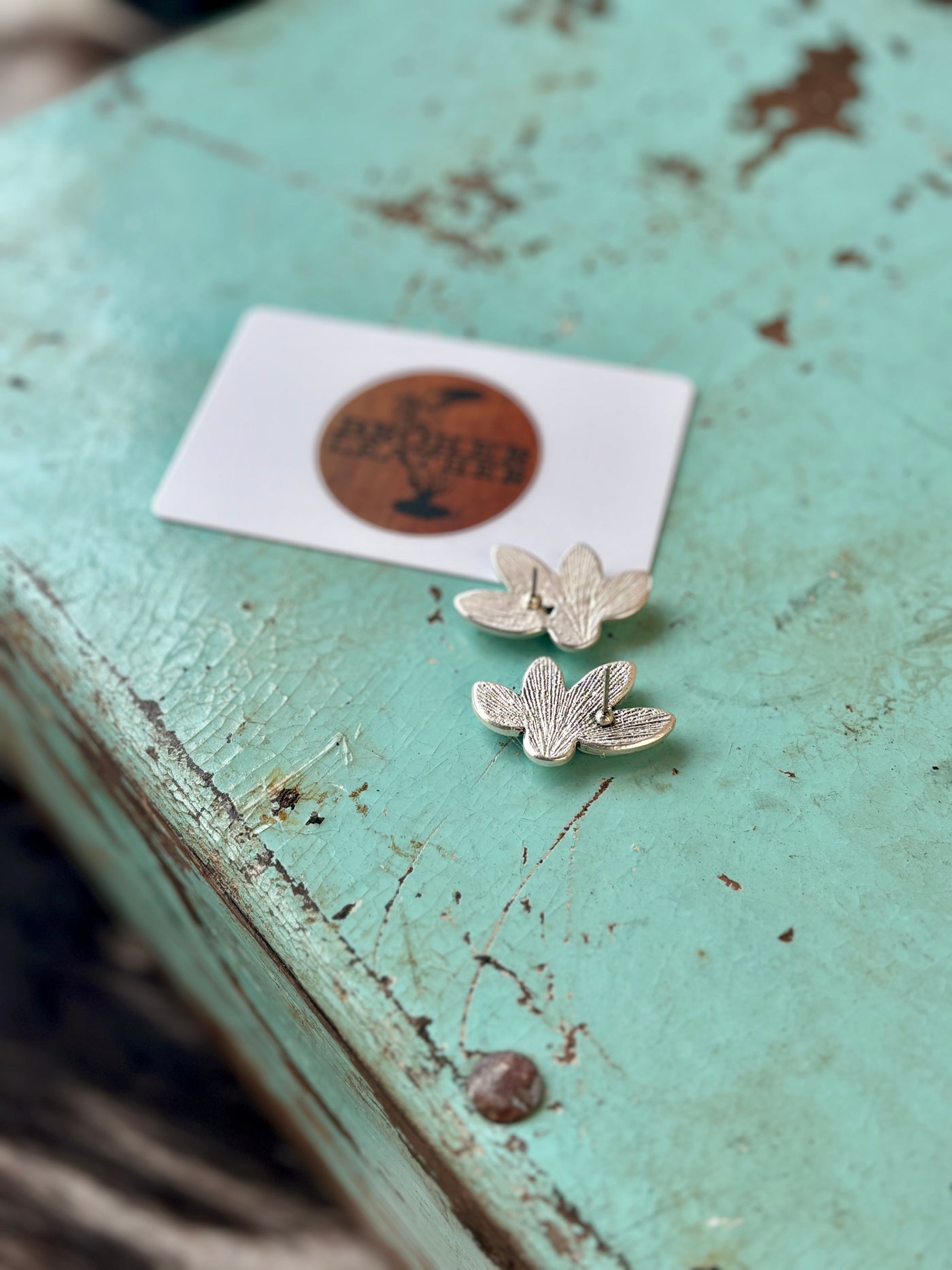 Back side view showing the post placement and size compared to a gift card of the Britton Faux white buffalo turquoise earrings.