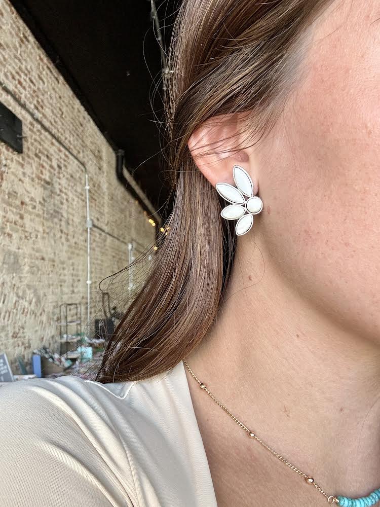 Close up photo of the Western-inspired Britton White Buffalo Cluster Earrings modeled by a Broker Leather employee to show size.