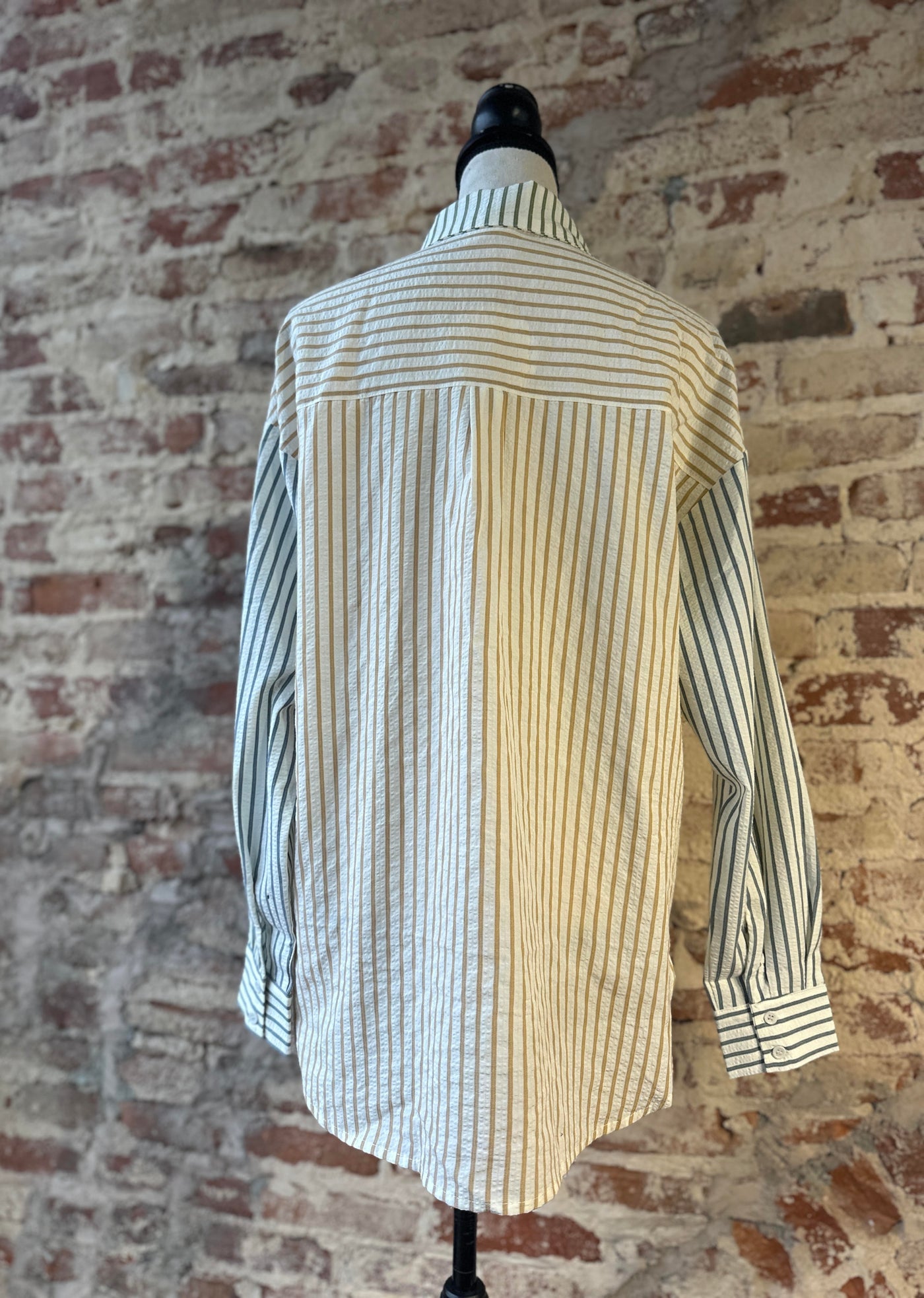 The reverse side of our Bryan Stripe Button Down Blouse Shirt on a mannequin showing the colorful stripes and flowy tunic-length silhouette.