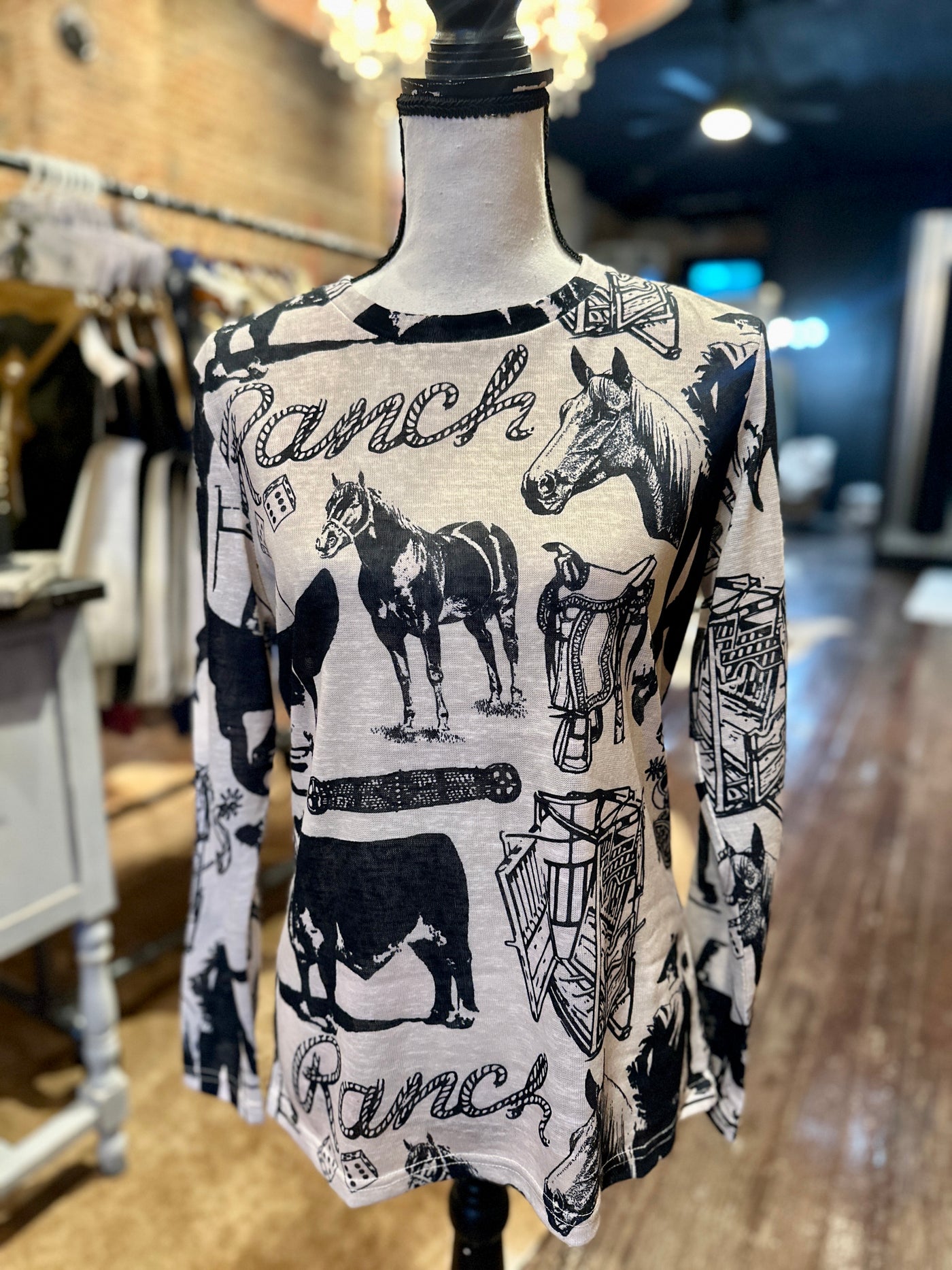 Burnin' Daylight Cowboy Graphic Top featuring bold Western-themed designs in black and white.