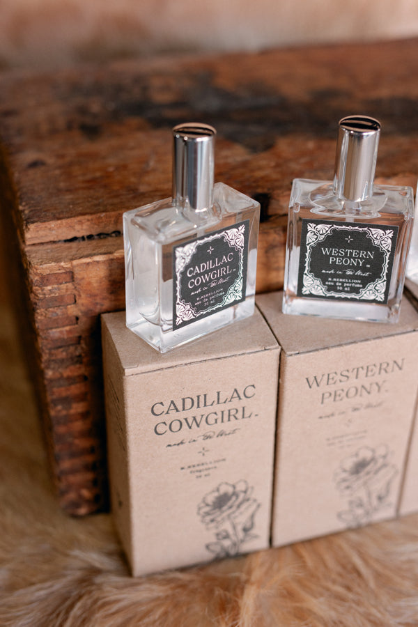 Photo of our glass bottle of Cadillac Cowgirl Perfume Spray with kraft box underneath.