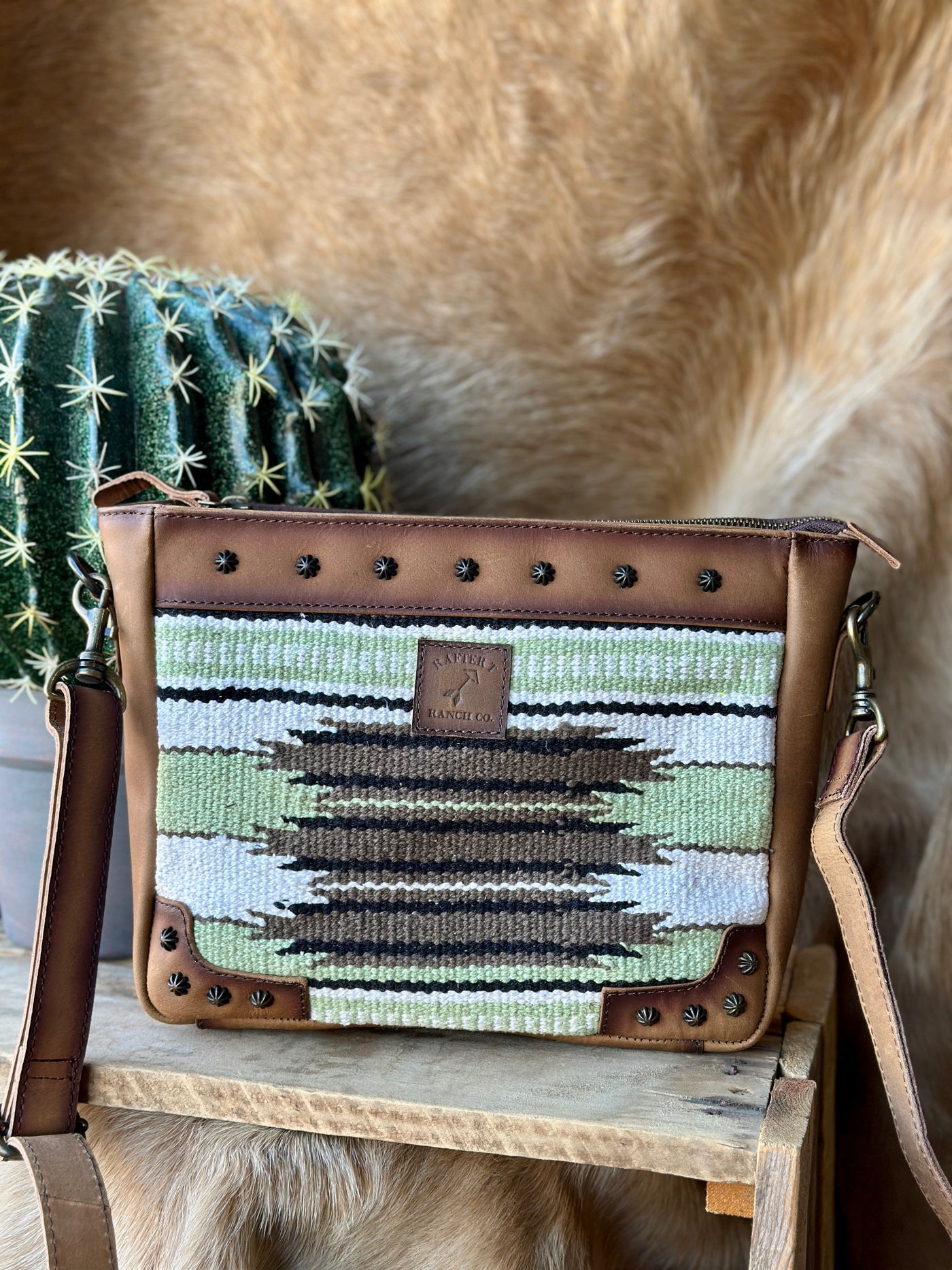 Calum Saddle Blanket Crossbody Bag – western-style woven Aztec print bag in brown, black, sage green, and cream.