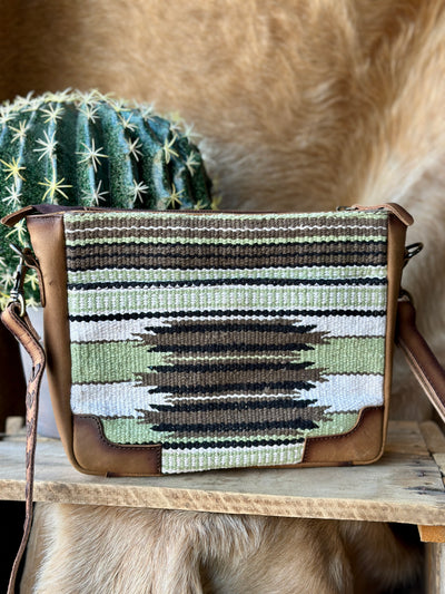 Western adventure-ready crossbody bag with woven canvas detailing and a vintage-inspired aesthetic.