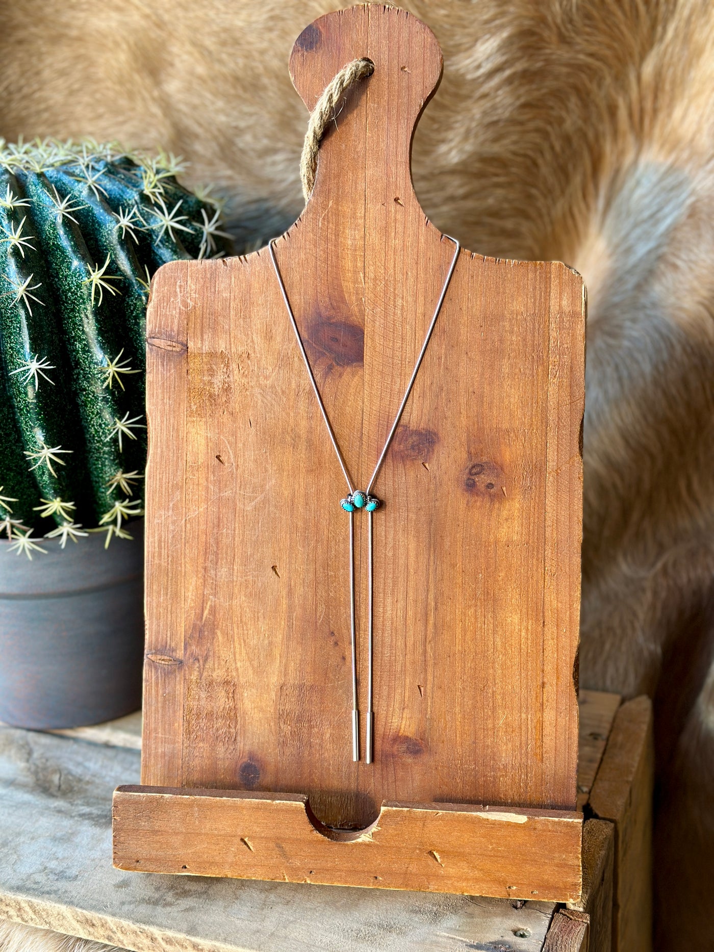 Sterling silver bolo necklace by Calvin, adorned with three turquoise gemstones in a half-cluster arrangement, adjustable for a custom fit.