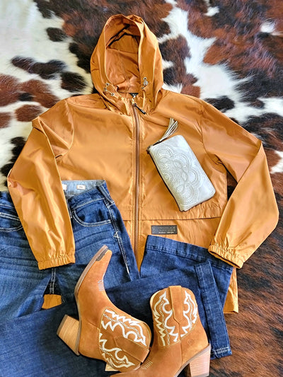 Stylish Carhartt Caliber Rain Jacket shown with Ariat denim jeans, Dingo cowboy boots and a leather wallet.