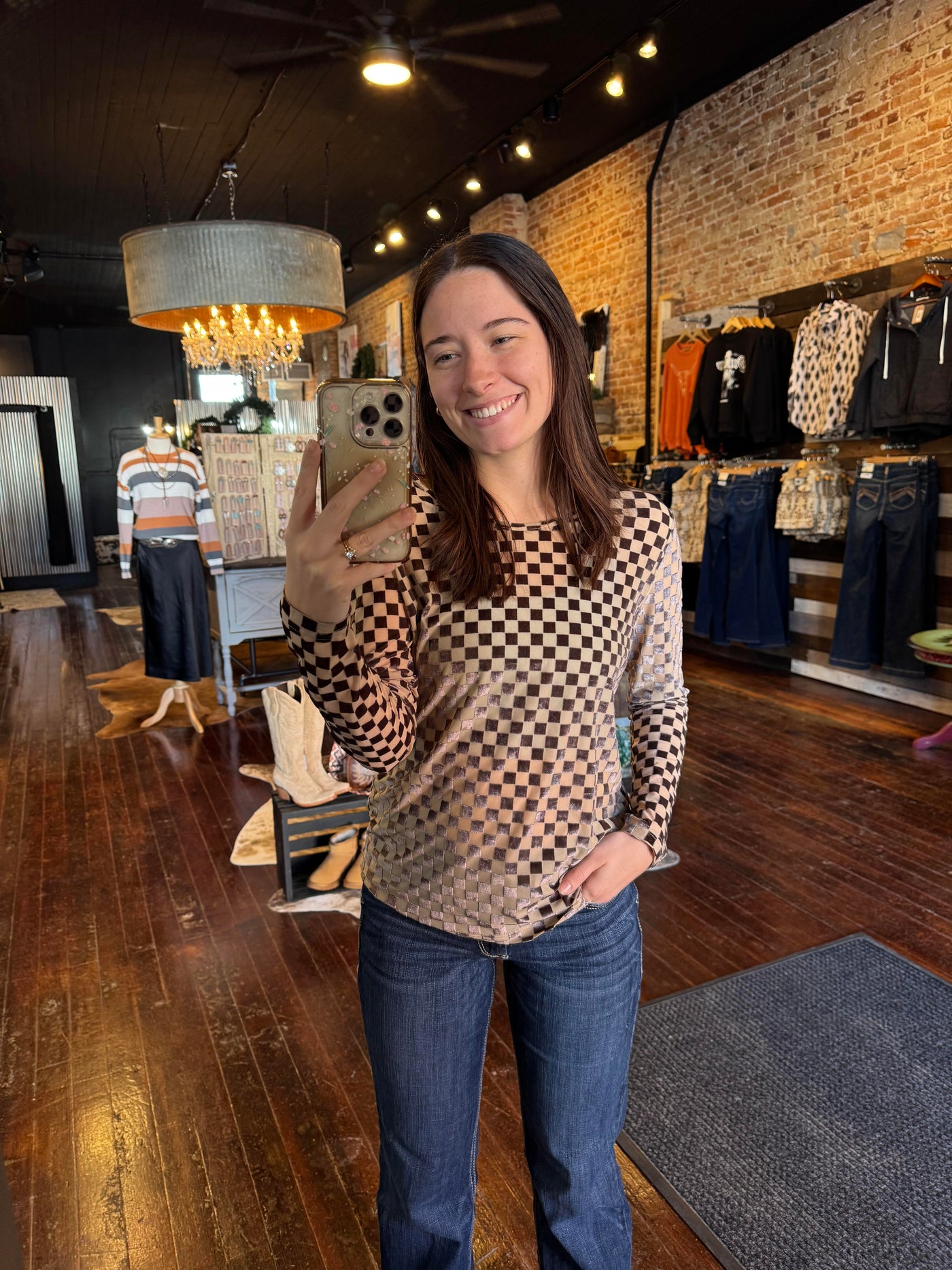 A Broker Leather employee modeling the Championship Long Sleeve Velvet & Mesh Top.