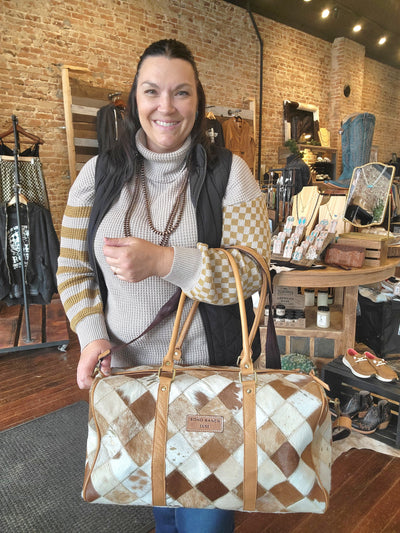 Broker Leather model showcasing Cody Checkered Cowhide Duffel Bag, a must-have for travel with unique hide patterns.