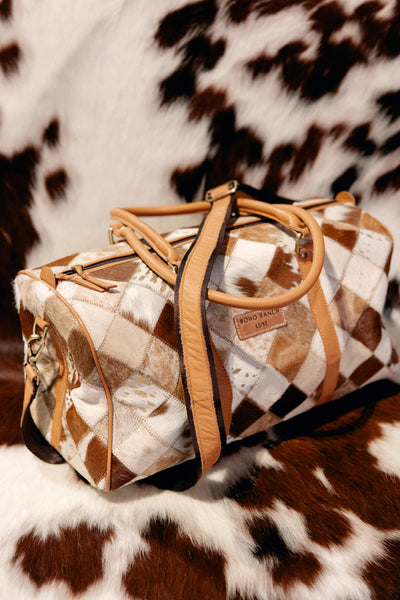 Durable and stylish cowhide duffel bag designed for cowgirls on the move.