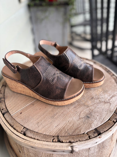 Brown wedge sandals with a cork-look sole and popular boot-stitch pattern.