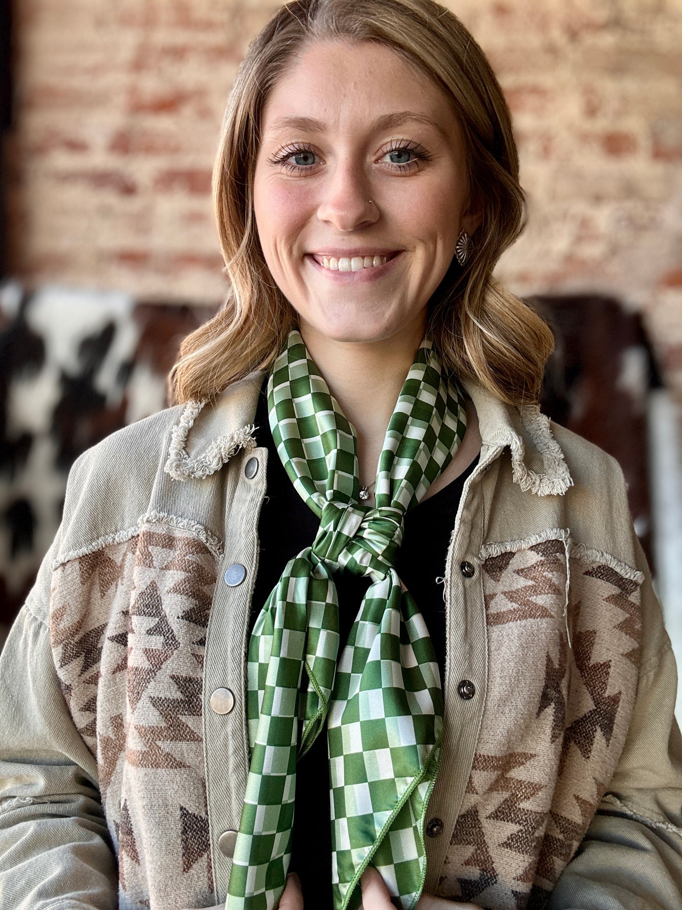 Soft and breathable Crew Chief wild rag with trendy checkered design for fashion-forward outfits modeled by Broker Leather Employee, Grace.