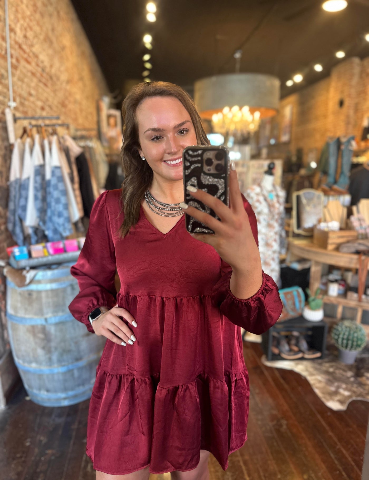 Flowy and lightweight 100% polyester dress in a rich burgundy shade modeled here by woman at Broker Leather.