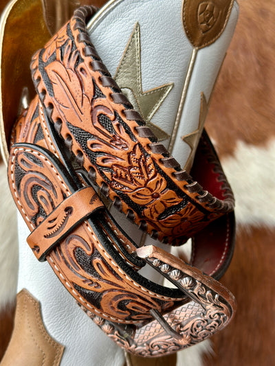 Close-up of Dahlia Tooled Leather Belt showcasing hand-tooled floral design and whipstitch edges.