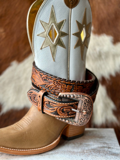 Brown tooled leather belt with intricate floral patterns and classic Western craftsmanship displayed with an Ariat boot.