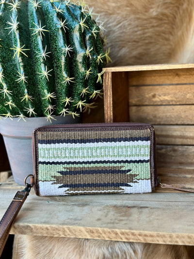 Rustic green and brown saddle blanket wallet featuring a zip closure and removable wristlet strap.