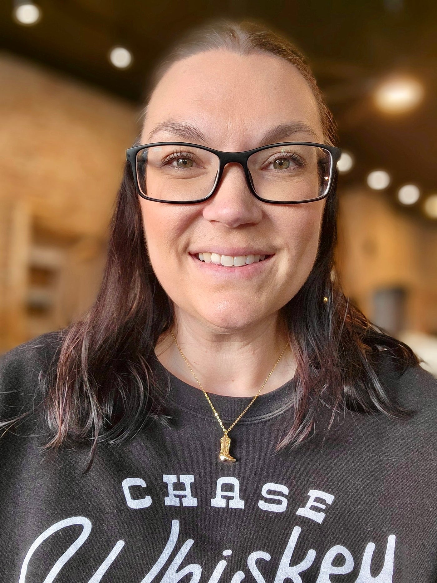 A Broker Leather employee modeling the new Damian Gold Cowboy Boot Necklace.