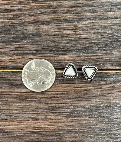 Western-inspired faux white buffalo stud earrings with intricate silver rope detail, displayed next to a quarter for size comparison.