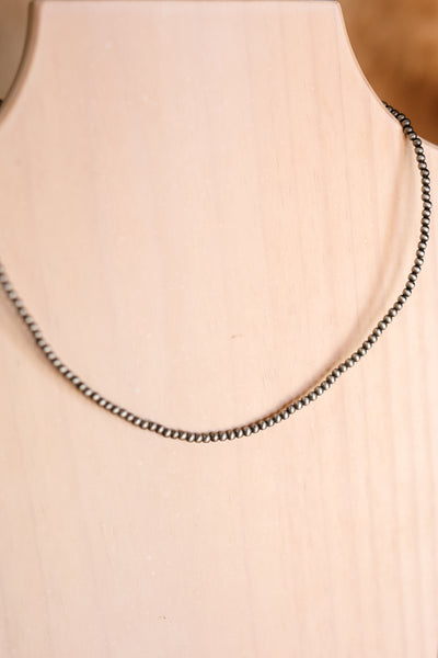 Close up of our Diamond Kitchen Faux Navajo Pearl Necklace on a wooden necklace holder.