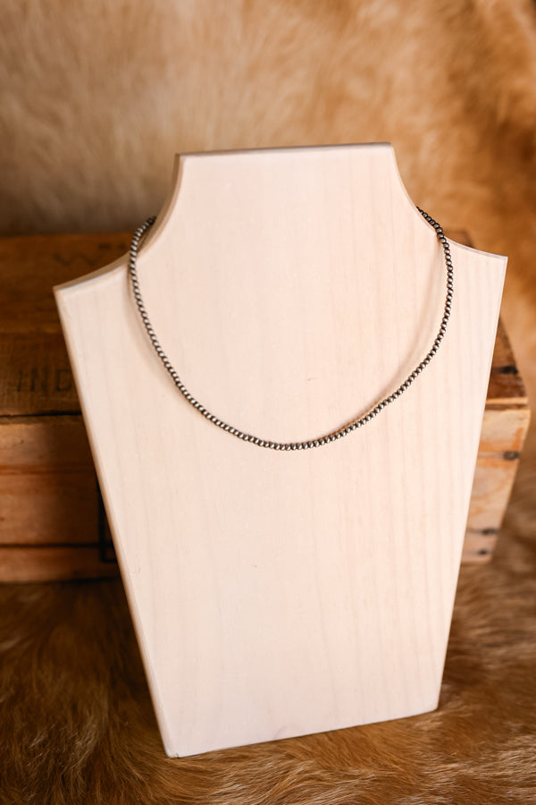 Photo of our Diamond Kitchen Faux Navajo Pearl Necklace on a wooden necklace bust.