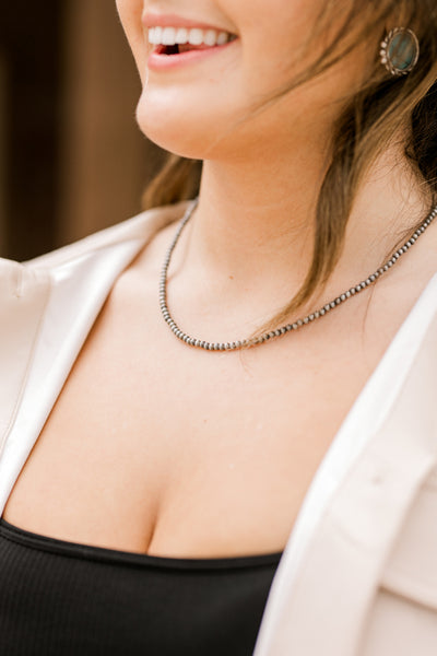 Close up of a woman modeling our Diamond Kitchen Faux Navajo Pearl Necklace.