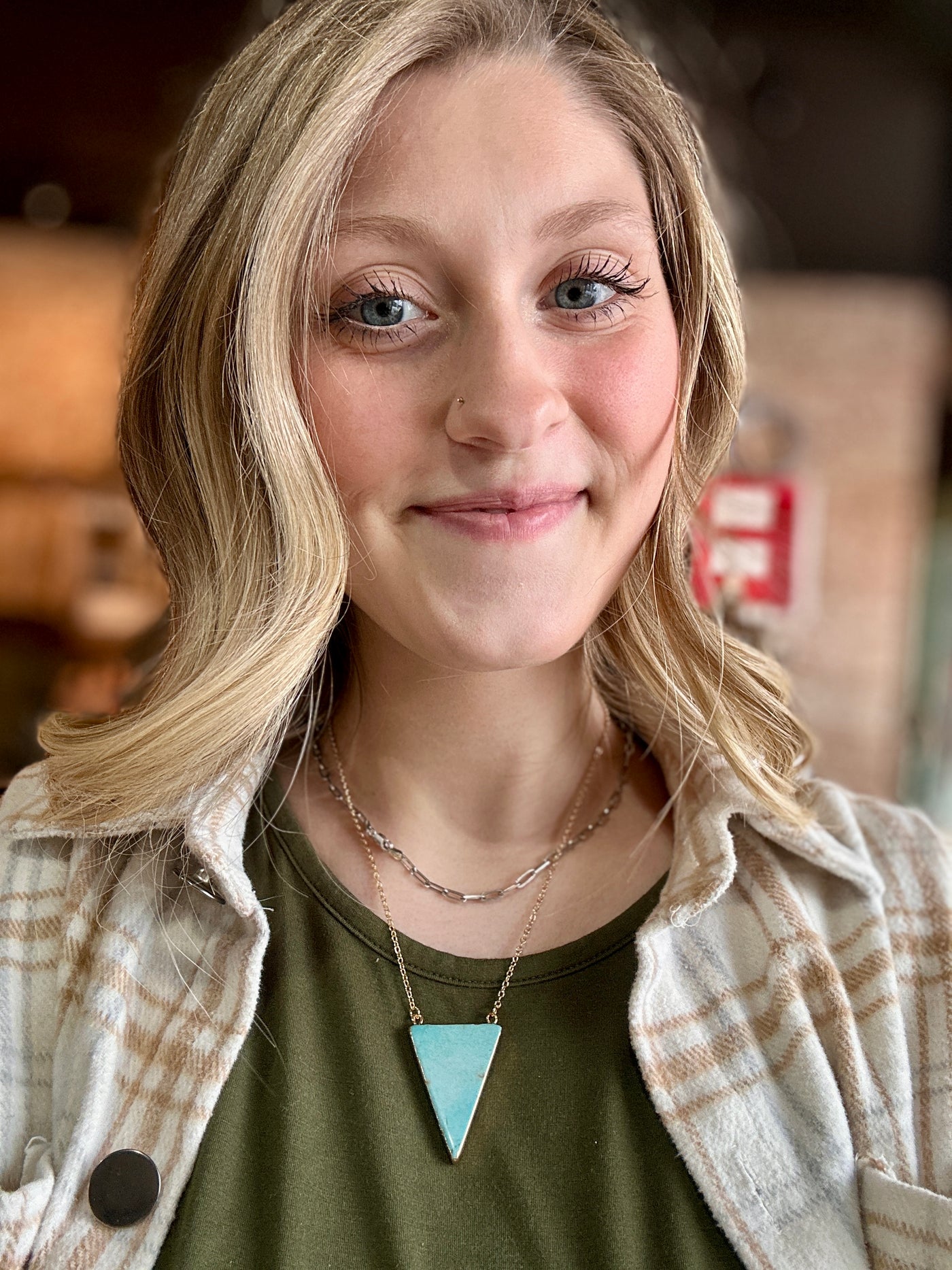 Turquoise triangle pendant necklace paired with a casual Western outfit.