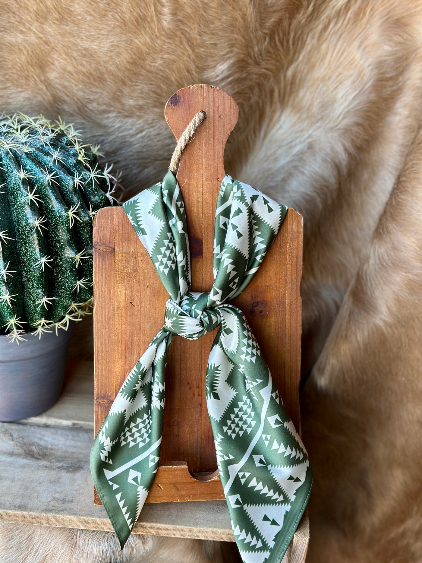 A unisex gift item: the Duvall Aztec Wild Rag in cream and olive green with a bold, retro-inspired Aztec design.