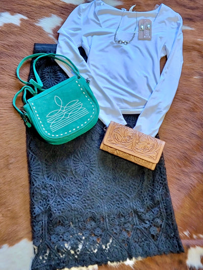 Elegant black lace midi skirt with delicate detailing paired with leather accessories and a basic white top.