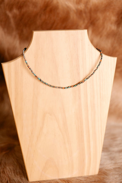 Erin Navajo Pearl & Turquoise Gemstone Necklace with 4mm round beads, displayed on a rustic background.