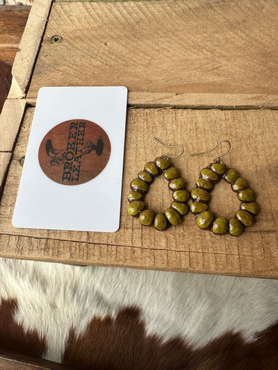 Flat lay of Formula One Clay Teardrop Earrings next to a gift card for size reference, measuring approximately 1.5 inches long.